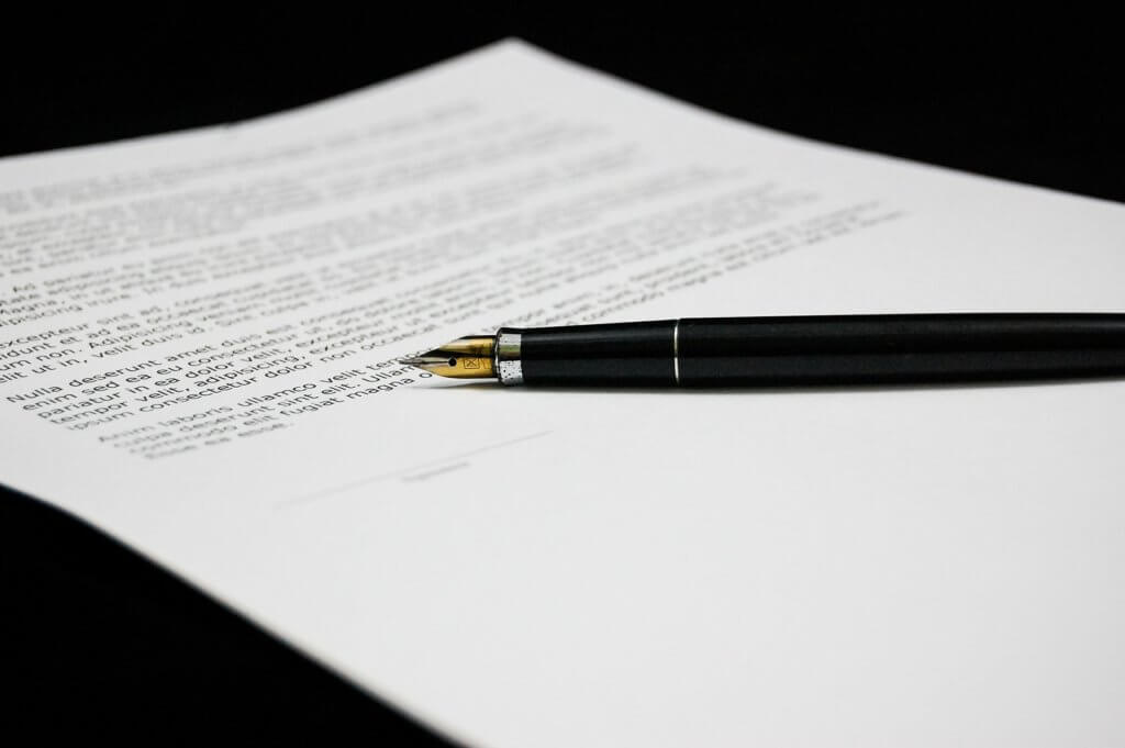 A contract and a pen on a black table